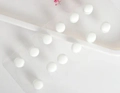 Close-up of white magnetic beads for scarves on a transparent acrylic display board - White (xz4599)
