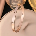 Elegante brazalete de acero inoxidable oro rosa con diseño minimalista de corazones calados. - Brazalete Corazón Calado / Rosa oro