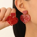 Sparkly red acrylic double heart drop earrings with Love cutout on model ear - Hollow Love Red Heart (DZ-467)