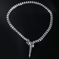 Detailed view of silver snake-head pendant and square link chain on black mirror - Necklace / Silver