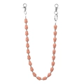 Detailed close-up of light pink skull beads and silver metal lobster clasps on a pant chain - Orange