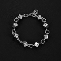 Dettaglio di un bracciale con dadi argentati su pelle nera, catena punk con moschettone - Bracciale con Dadi 23CM