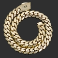 Macro detail of 14K gold Cuban chain with iced out S-logo buckle on black background - 15mm / 24 inch / Gold