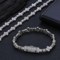 Dettaglio macro del set bracciale e collana a fiore incrociato con zirconi incastonati - Bracciale 7 Pollici / Platino
