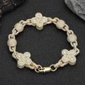 Macro view of gold hip-hop bracelet with pavé cubic zirconia and clover links - 7 inches / Gold