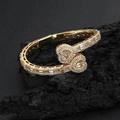 Luxurious gold double heart open bangle with zircon inlay on textured rock background - Gold