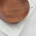 Elegante S999 Silber Herz Halskette mit ineinandergreifenden Ringen auf einer Holzschale - 990 Silber / Weißgold
