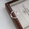 Minimalistischer S999 Silber Mobius Ring auf einer dunklen Schmuckschatulle aus Holz - Einstellbar Offen / Silber