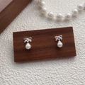 Elegant S999 silver bow earrings with round white pearls on a minimalist wood stand - 990 Silver / Silver