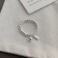 Minimalistischer S925 Sterlingsilber Perlenring mit Fisch- und Glockenanhängern auf Stoff - Einheitsgröße / Silber