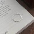 Anillo abierto de plata de ley S999 con diseño de bambú sobre una página de un libro - Abierto Ajustable / Plateado