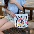 White canvas tote bag with colorful cartoon angel girls print and black handles on wooden bench - Fairytale Paradise