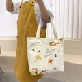 White canvas tote bag featuring autumn harvest illustrations and durable beige handles - Autumn Leaf