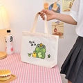 Off-white canvas tote bag featuring cute cartoon frog and chick illustrations with handles - Frog / Frog - Beige