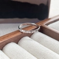 Interlocking S925 sterling silver couple ring set with zircon pavé on a wooden display - Female Style / White Gold