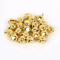 Makroaufnahme von polierten Gold-Kupfer-Miniglocken für DIY-Schmuck auf weißem Hintergrund - Zahl 6 / Gold