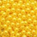Macro shot of bright yellow round acrylic pearl beads with pre-drilled holes for DIY jewelry - Yellow