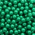 Macro shot of emerald green round acrylic pearls with center holes for DIY jewelry making - Dark Green