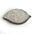 Detalle de cuentas de hierro plateadas para joyería DIY en una bandeja de cerámica verde - Diámetro 2.4mm Apertura 0.6mm Aprox 1000uds/Pack / Plateado