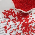 Macro shot of 2-3mm transparent red glass seed beads for DIY jewelry making - Red