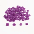 Macro view of purple resin snap fastener components including caps and sockets - Deep purple