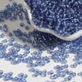 Durchscheinende Glasperlen in Blau mit Silbereinzug auf weißem Keramikteller für DIY - Blau