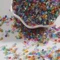Macro shot of 2mm colorful glass tube beads spilling from a white bowl for DIY jewelry - 2mm 15g/Pack Approx 700pcs / Random Mixed Colors