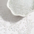 Vista macro de cuentas de vidrio transparentes AB de 2mm en un cuenco de pétalos - 2mm Paquete de 15g Aprox 1000 Unidades / Blanco AB