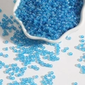 Detalle macro de cuentas de vidrio azul translúcido para joyería DIY en un cuenco blanco - 2mm Paquete de 15g Aprox 1000 Unidades / Azul Lago AB