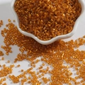 Golden glass tube beads for DIY jewelry making displayed in a white floral dish - 2mm (15g/Pack) / Orange