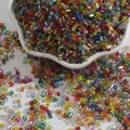 Mix of colorful glass bugle beads in a ceramic bowl for DIY jewelry and crafts - 2mm (15g/Pack) / Random Mixed Colors
