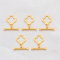 Detailed macro view of five 18K gold-plated clover-shaped OT toggle clasps on white silk - Four-leaf Flower Style