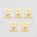 Détail macro de cinq fermoirs à bascule fleur dorés 18K sur fond de soie blanche - Fleur à cinq pétales