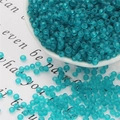 Detail of frosted cyan glass seed beads on a white porcelain dish for DIY jewelry making - 3mm 20g/Pack Approx 700 Pcs / Peacock Blue
