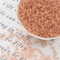 Frosted peach seed beads in a white ceramic dish for DIY handmade jewelry crafting - 3mm 20g/Pack Approx 700 Pcs / Flesh Pink