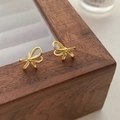 Detailed view of elegant gold bow earrings featuring a delicate twisted linear design - Gold