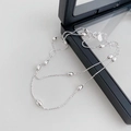 Dettaglio della collana in argento con grani ovali lucidi su supporto nero elegante - Argento 925 / Perla di Oliva Argento