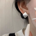 Primo piano di orecchini geometrici in argento sterling spazzolato indossati - Rombo Spazzolato / Argento