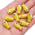 Handmade yellow ceramic fish-shaped beads for DIY jewelry making on a palm - 10x19mm (2 Pieces/Pack) / Yellow
