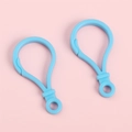 Crochets porte-clés bleu clair en acrylique pour DIY sur un fond rose pastel - Rose bonbon