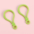 Paire de mousquetons en plastique vert vif avec clip à ressort sur fond rose - Vert clair