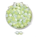 Macro detail of translucent green and blue cat eye beads in a decorative silver tray - Yellow Grey