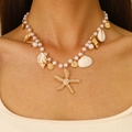 Bohemian seashell necklace with faux pearls and gold starfish charms on a model - KC Gold Shell Necklace (7511)