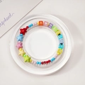 Colorful beaded bracelet with star shapes and 'WEDNESDAY' letters on display - Acrylic Round Style
