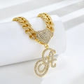 Detail of a golden Cuban link necklace with rhinestone heart and letter A pendant - Golden Letter A