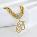 Macro shot of Cuban link chain with gold finish and iced-out letter B heart pendant - Golden Letter B