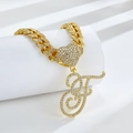 Détail de chaîne cubaine dorée avec cœur en strass et pendentif lettre initiale F - Lettre F Dorée