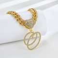 Détail macro du collier gourmette dorée avec pendentif cœur et lettre Q sertis - Lettre O Dorée