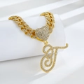 Détail de la chaîne cubaine dorée avec un cœur serti de diamants et un pendentif lettre T - Lettre T Dorée