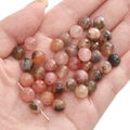 Pink and brown natural stone faceted beads for DIY bracelets shown on palm - Pink Blossom Agate / 8mm